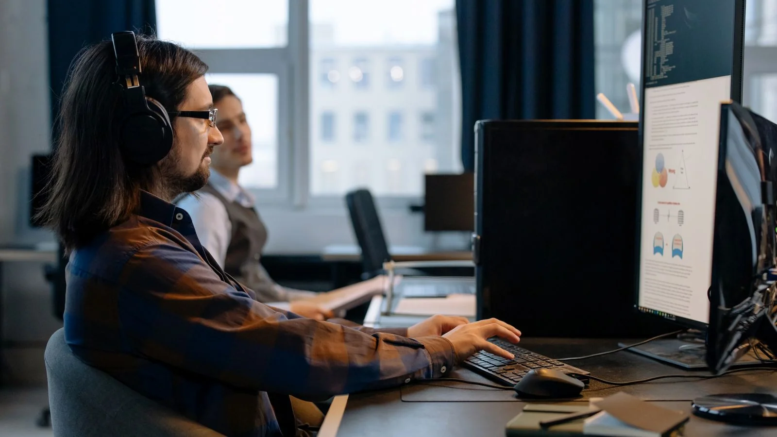 Two developers working together at a shared monitor, the kind of small team that buys a self-serve AI visibility tool