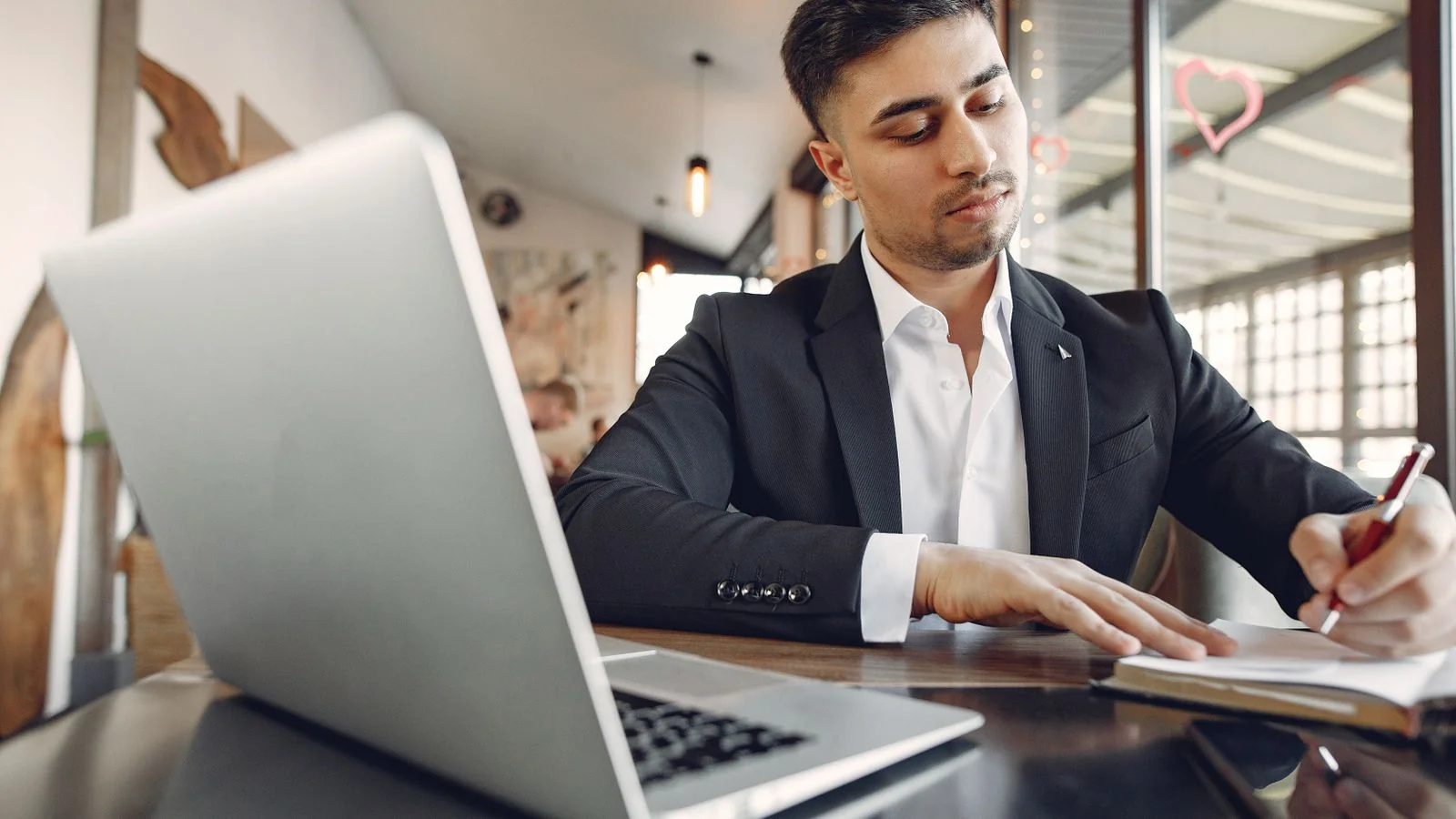 Executive taking notes at a laptop while drafting a promotion announcement