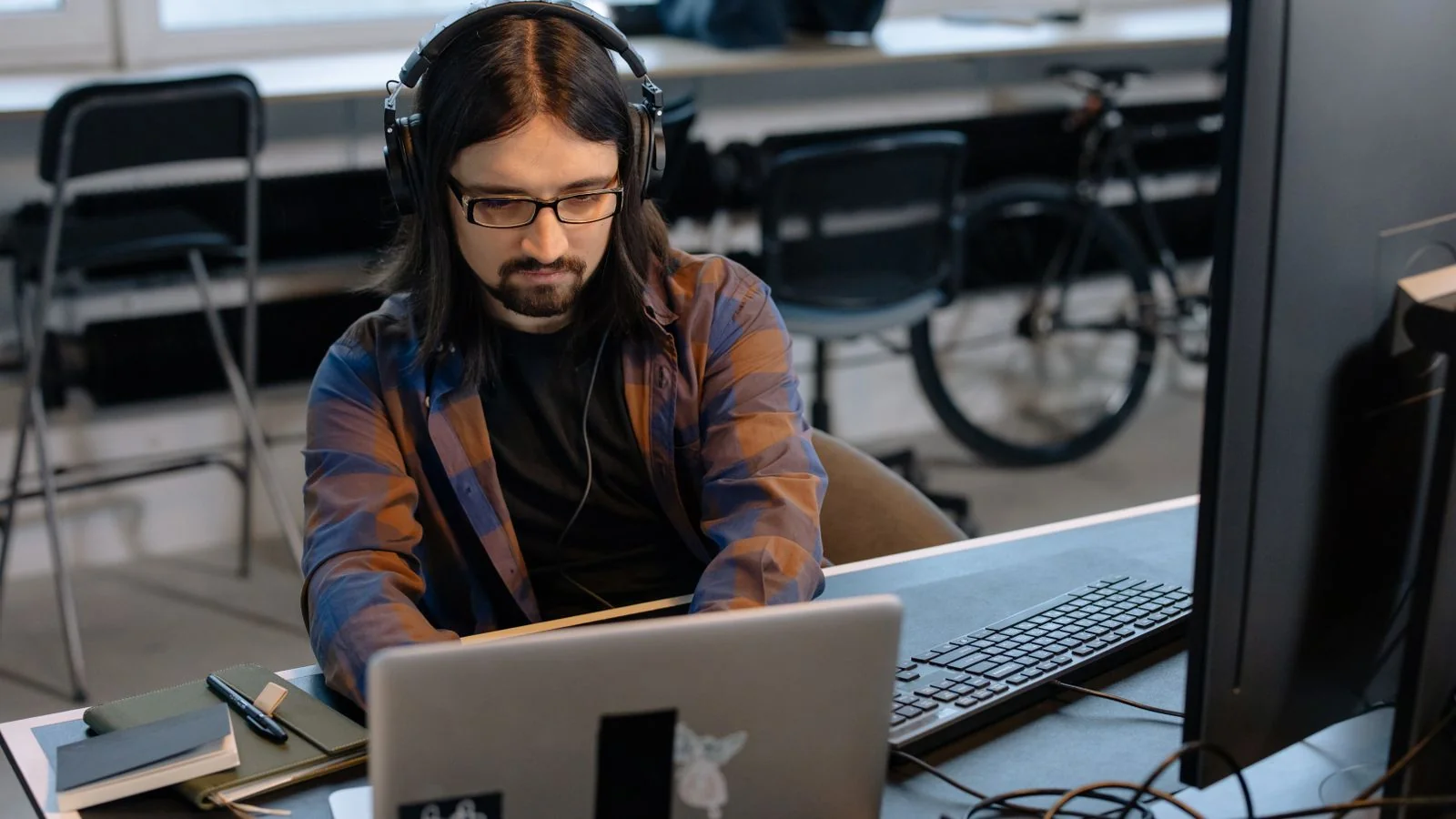 A developer at a monitor in a quiet office, the single-person inbox absorbing a hundred pitches a week