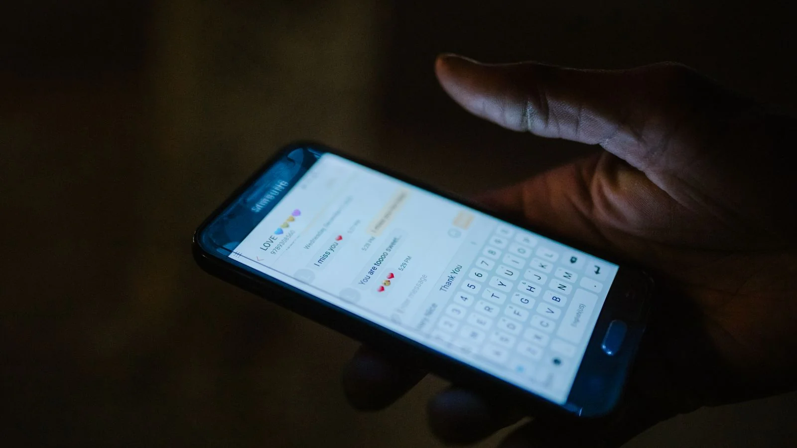 A hand holding a smartphone with a messaging app open, where most complaints about a building now begin.
