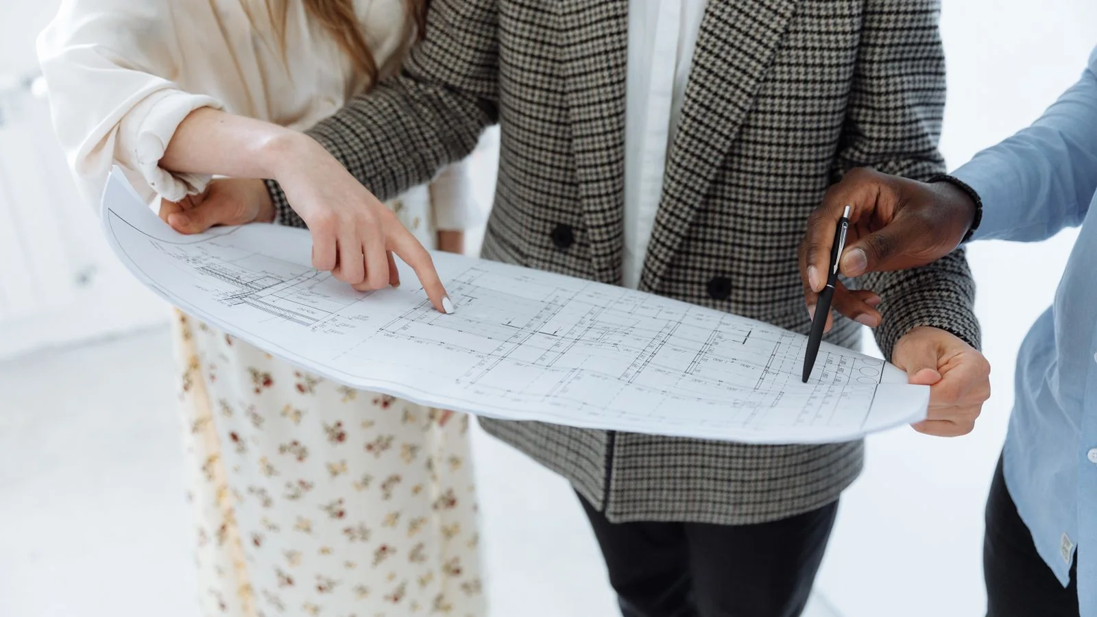 Adults reviewing detailed floor plans indoors, the same close reading your search results deserve.