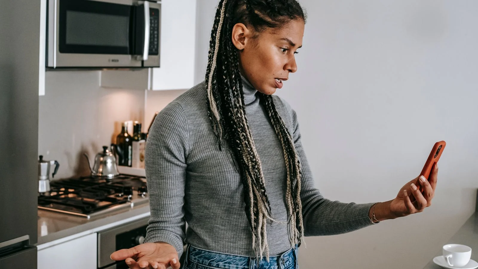 Homeowner on a tense phone call in her kitchen, the moment a remodel review gets written in her head.