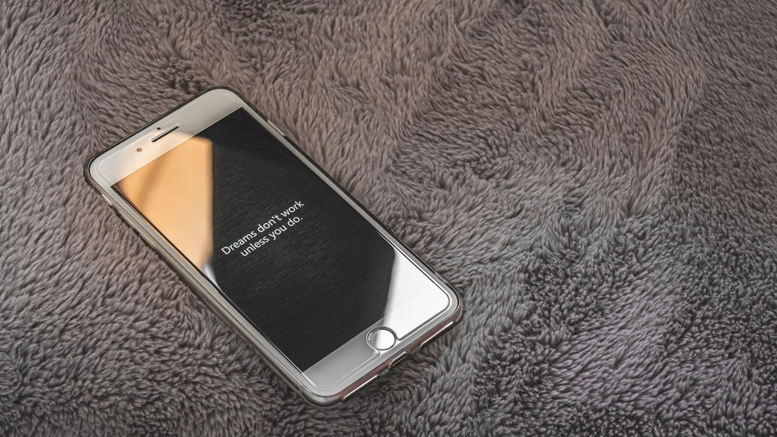 Smartphone resting on a gray blanket, the screen where a homeowner reads your reply to a bad review.