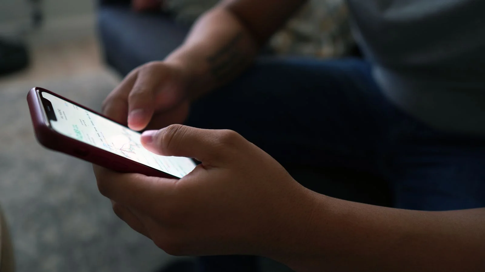 A person reading reviews on a smartphone at home before choosing who to call.