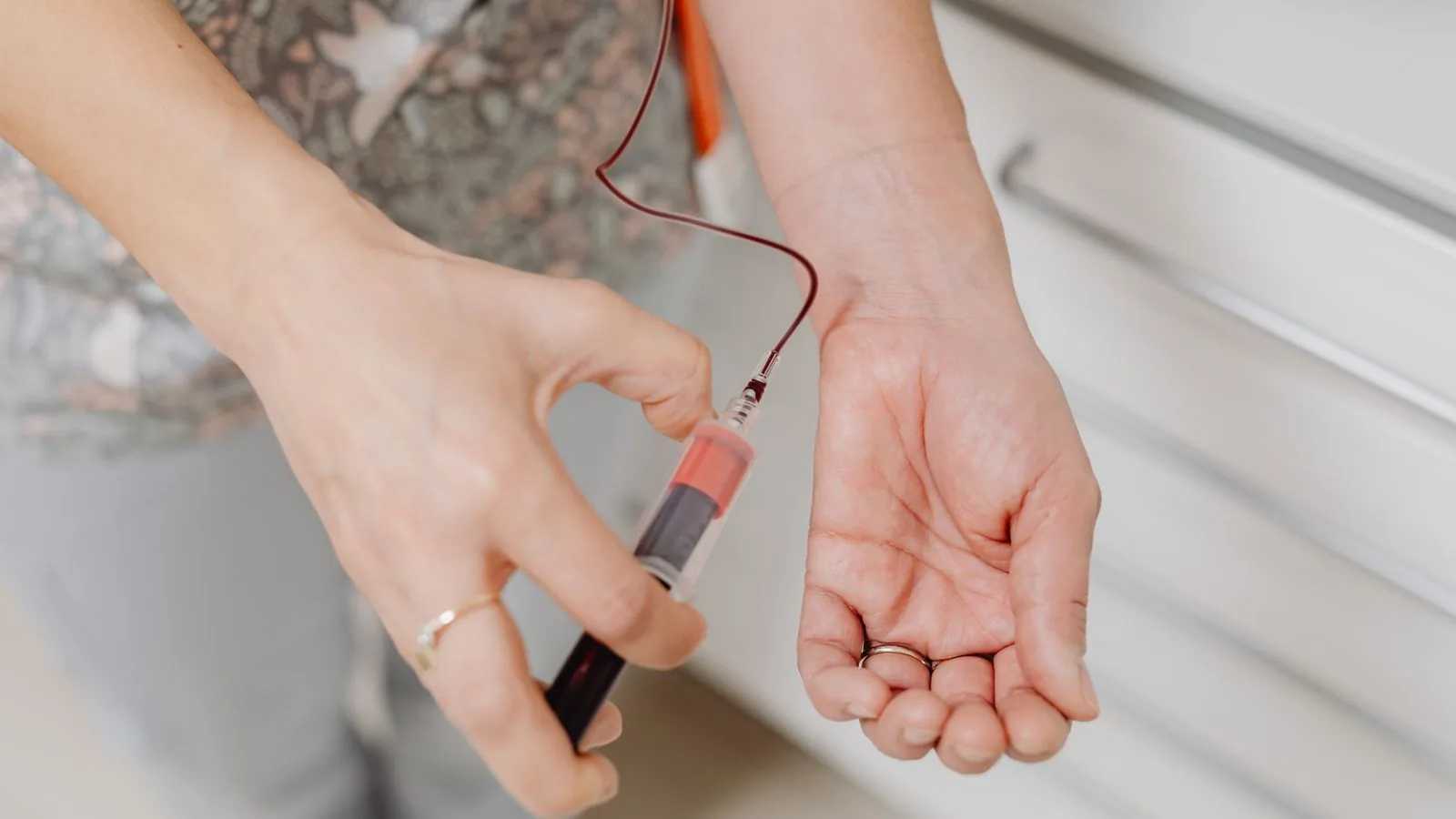 A close-up of a cannulation and vial, the clinical moment clients grade against a hospital standard