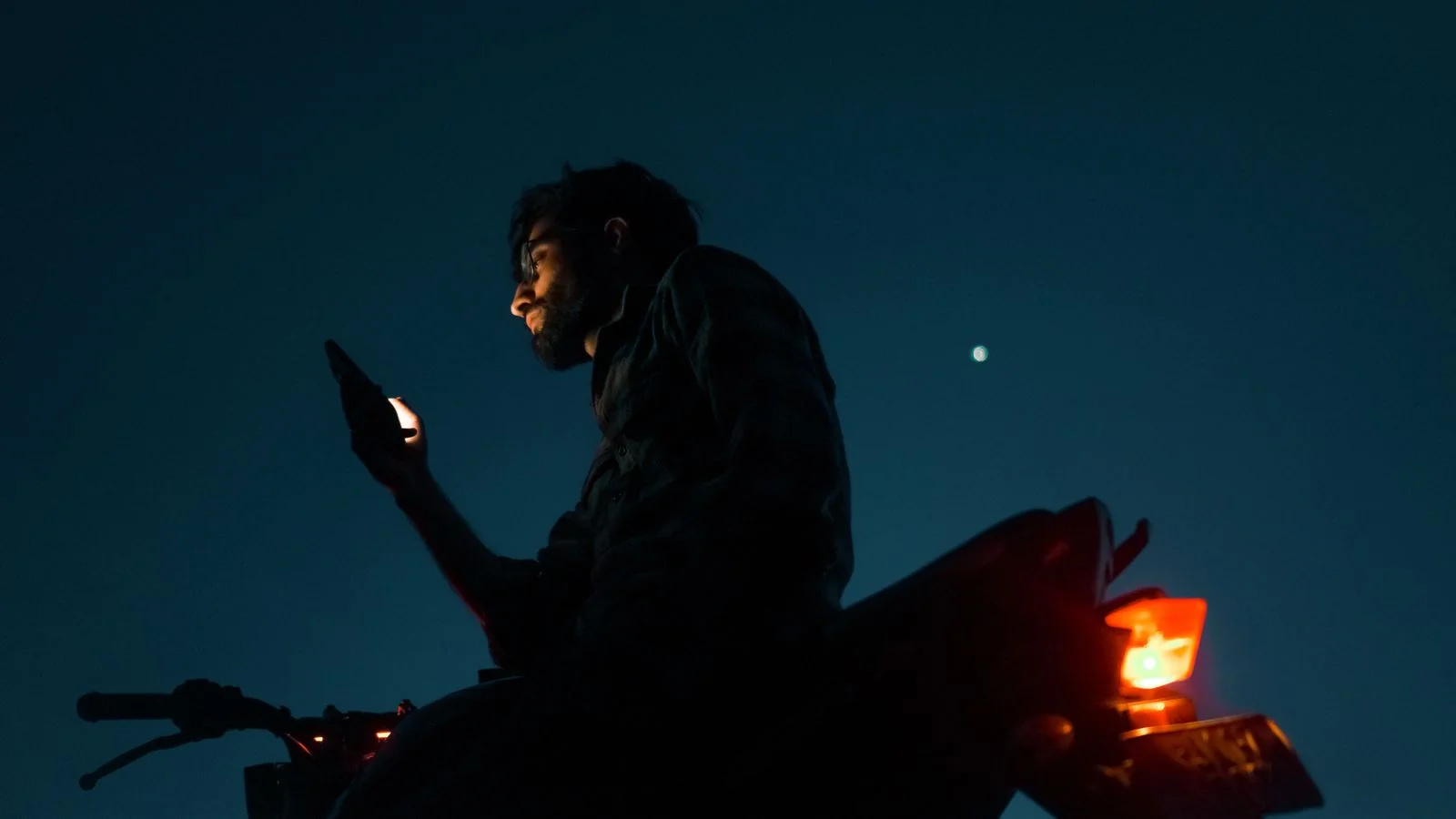 A person checking their phone at night, the moment a customer pulls up your rating before calling.