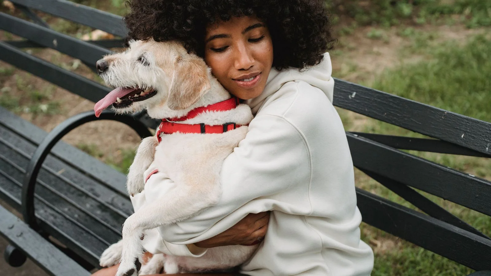 A dog owner hugging her dog affectionately.