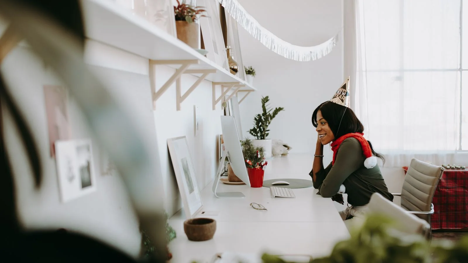 A smiling new hire at a decorated office desk during their first days in a role.