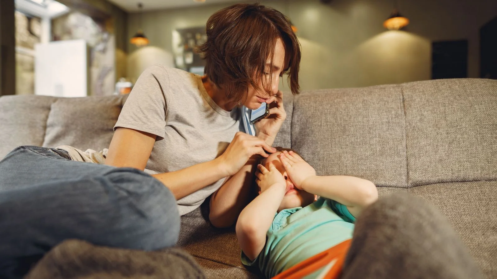 A parent making an anxious phone call at home, the way a homeowner dials for emergency septic help.