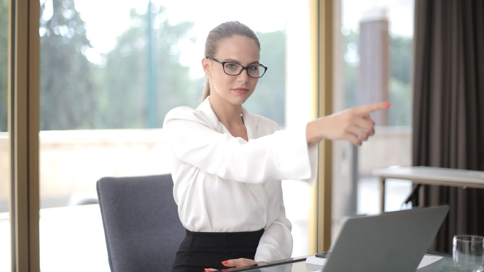 A focused professional working on a laptop in an office, reviewing feedback.