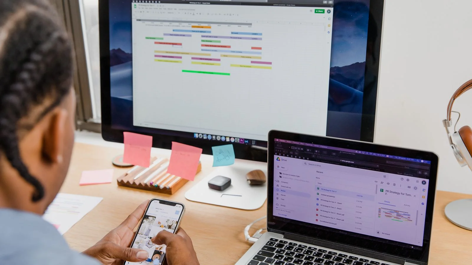 A professional checking brand alerts across a phone, laptop, and desktop monitor at once