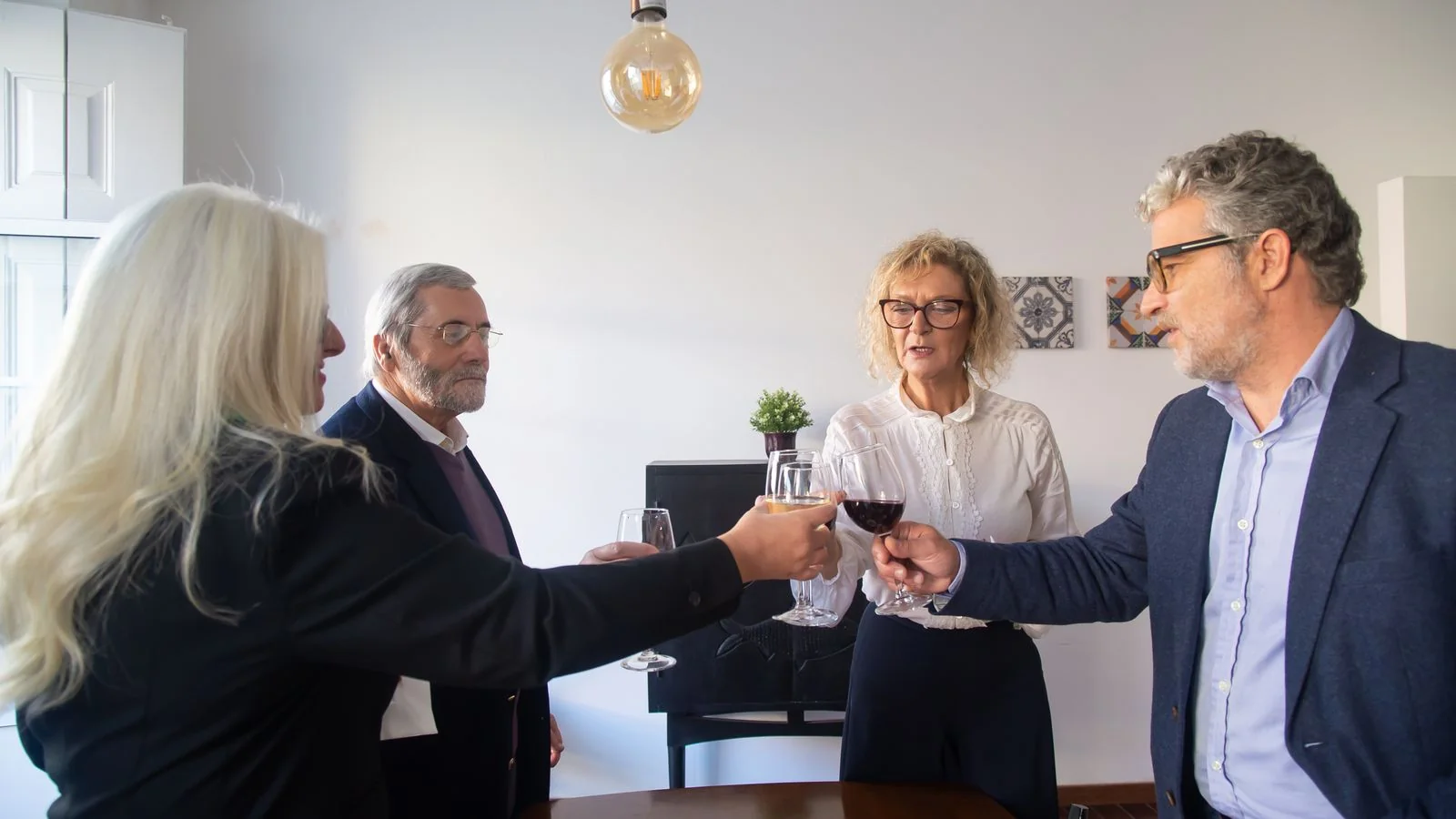 Business professionals raising wine glasses in a corporate setting to mark a leadership transition