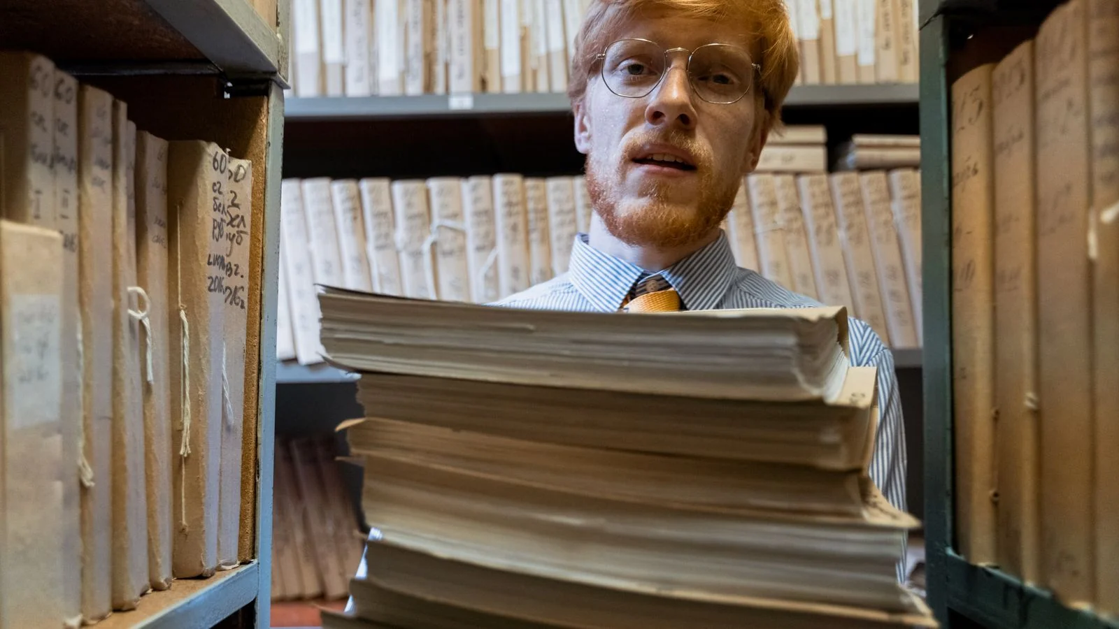 A person carrying a stack of documents through a library archive, the retrieval step RAG performs in an instant