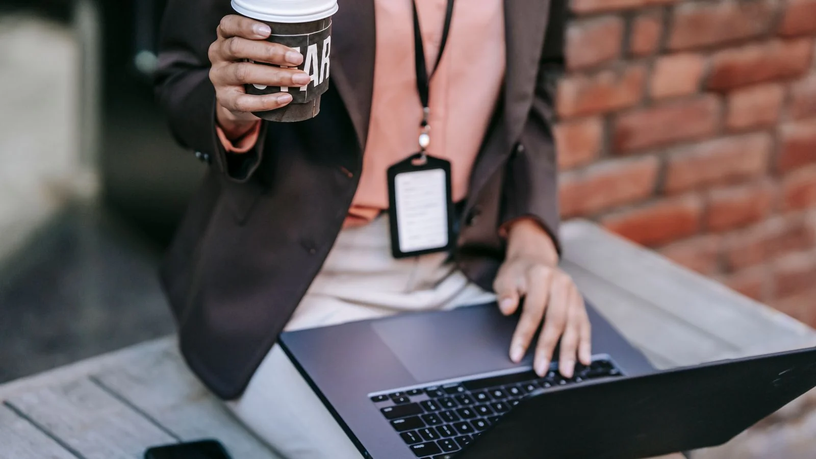 A businesswoman using a laptop with coffee, responding to customer reviews from her desk