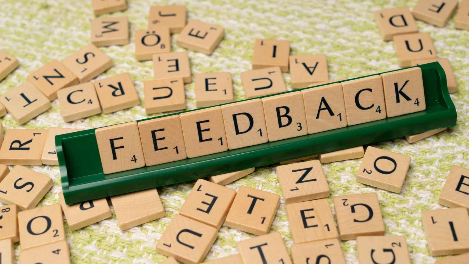 Wooden letter tiles spelling the word feedback, the raw material of both reviews and testimonials