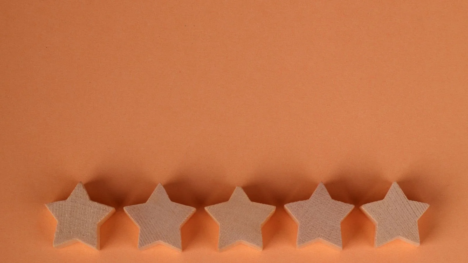 A single wooden five-star rating on a warm background, the compressed signal buyers scan for first