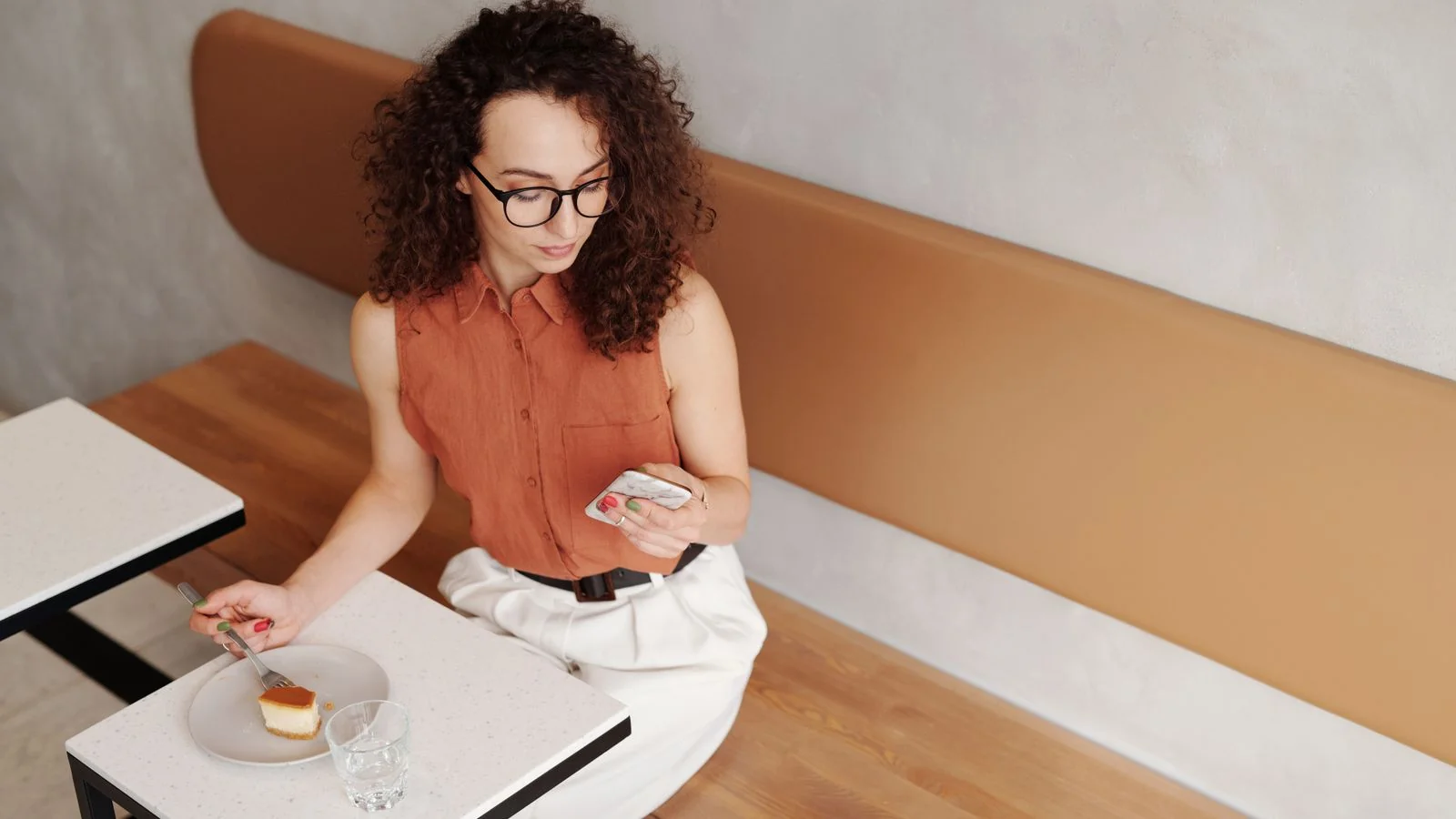 Woman checking her smartphone over dessert in a stylish cafe