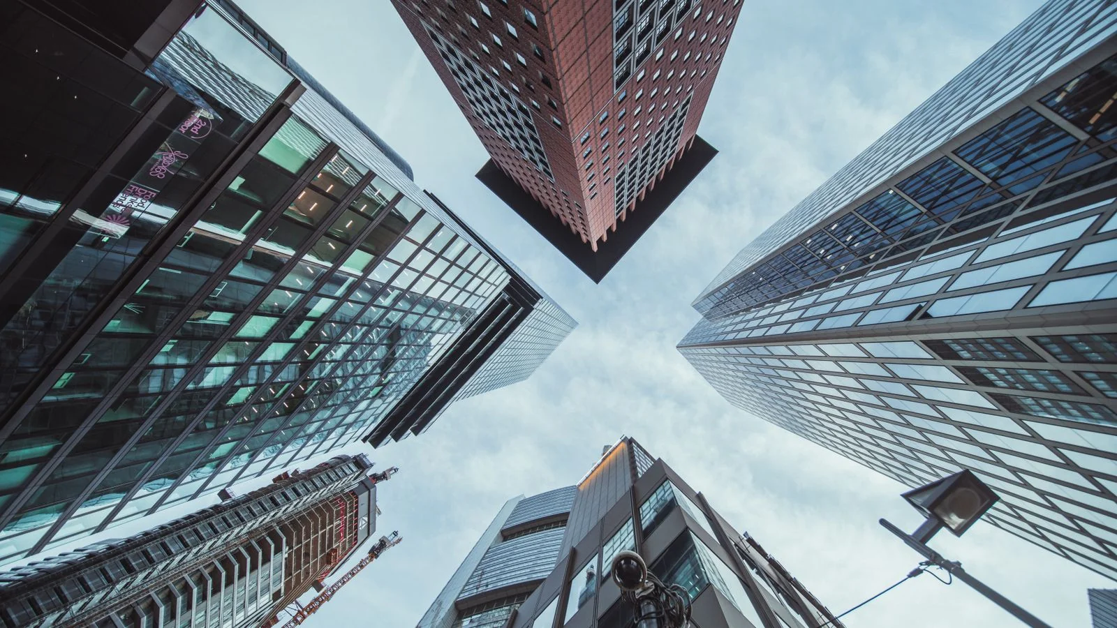 A dramatic upward view of city skyscrapers, the reach-higher instinct the technique is often reduced to
