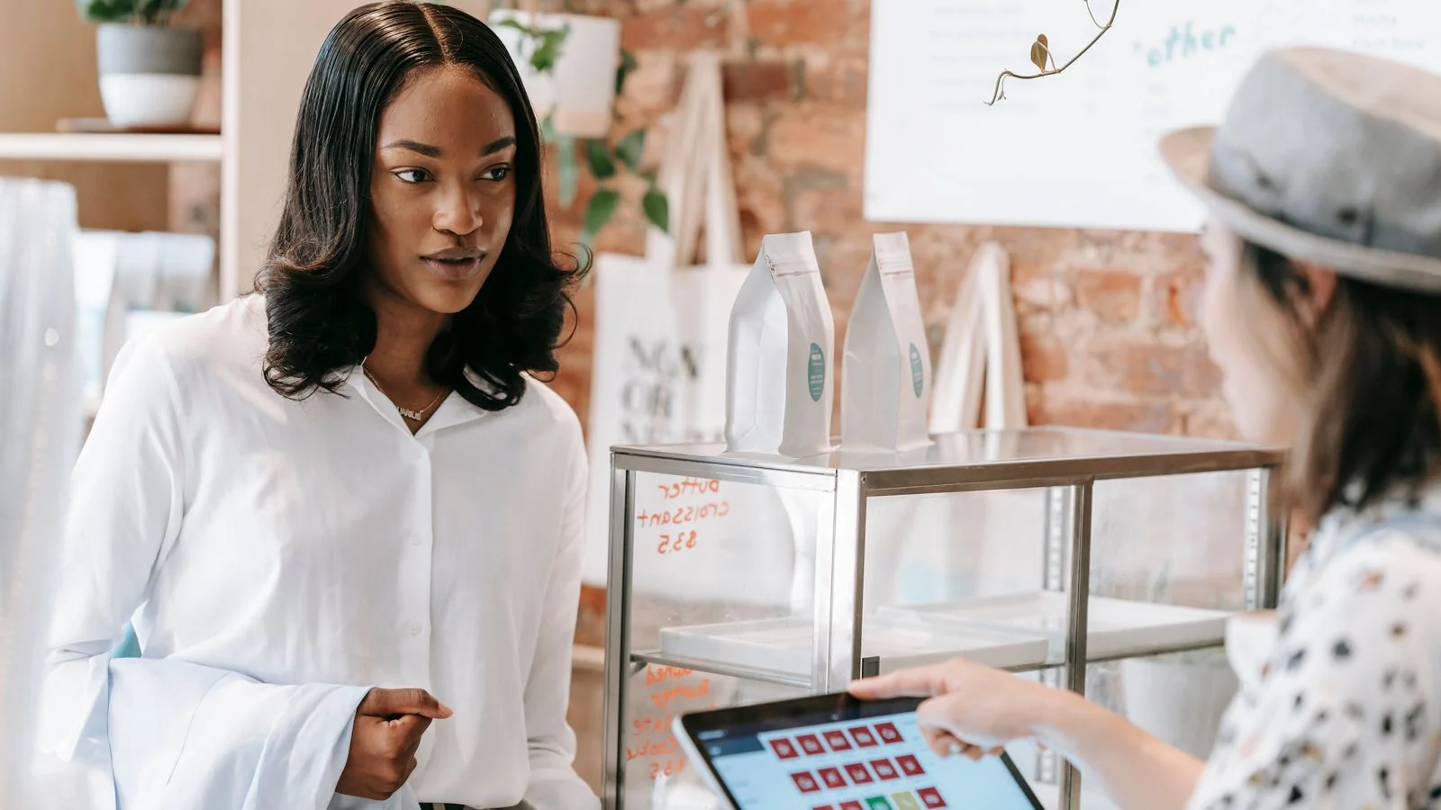 A customer being served by a barista at a small coffee shop counter, where marketing turns into revenue