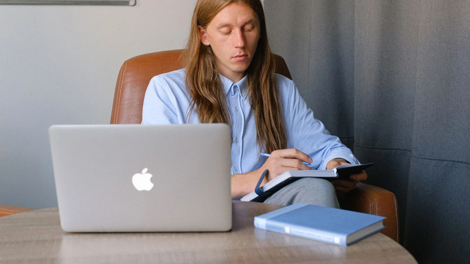 Writer working at a desk with a laptop and reference notes