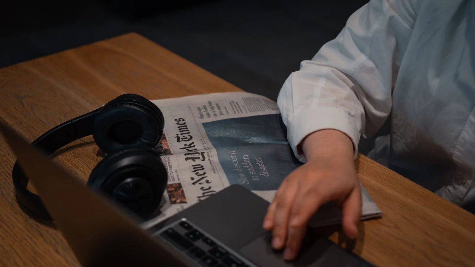 Journalist scanning a story on a laptop in a newsroom