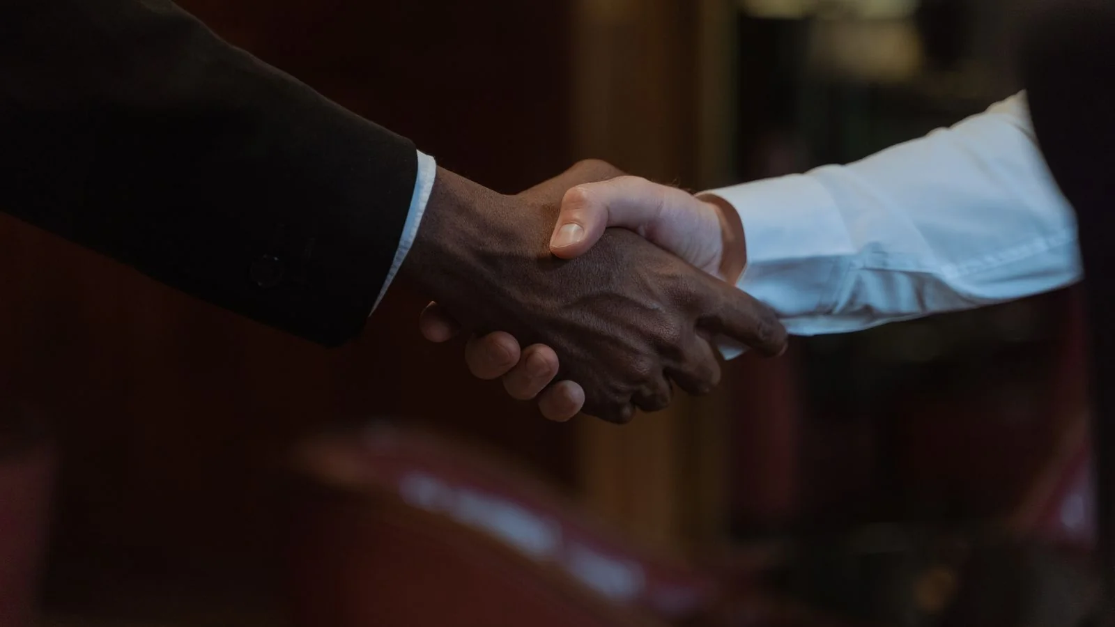 Two business owners shaking hands after a deal, the trust that press coverage helps build