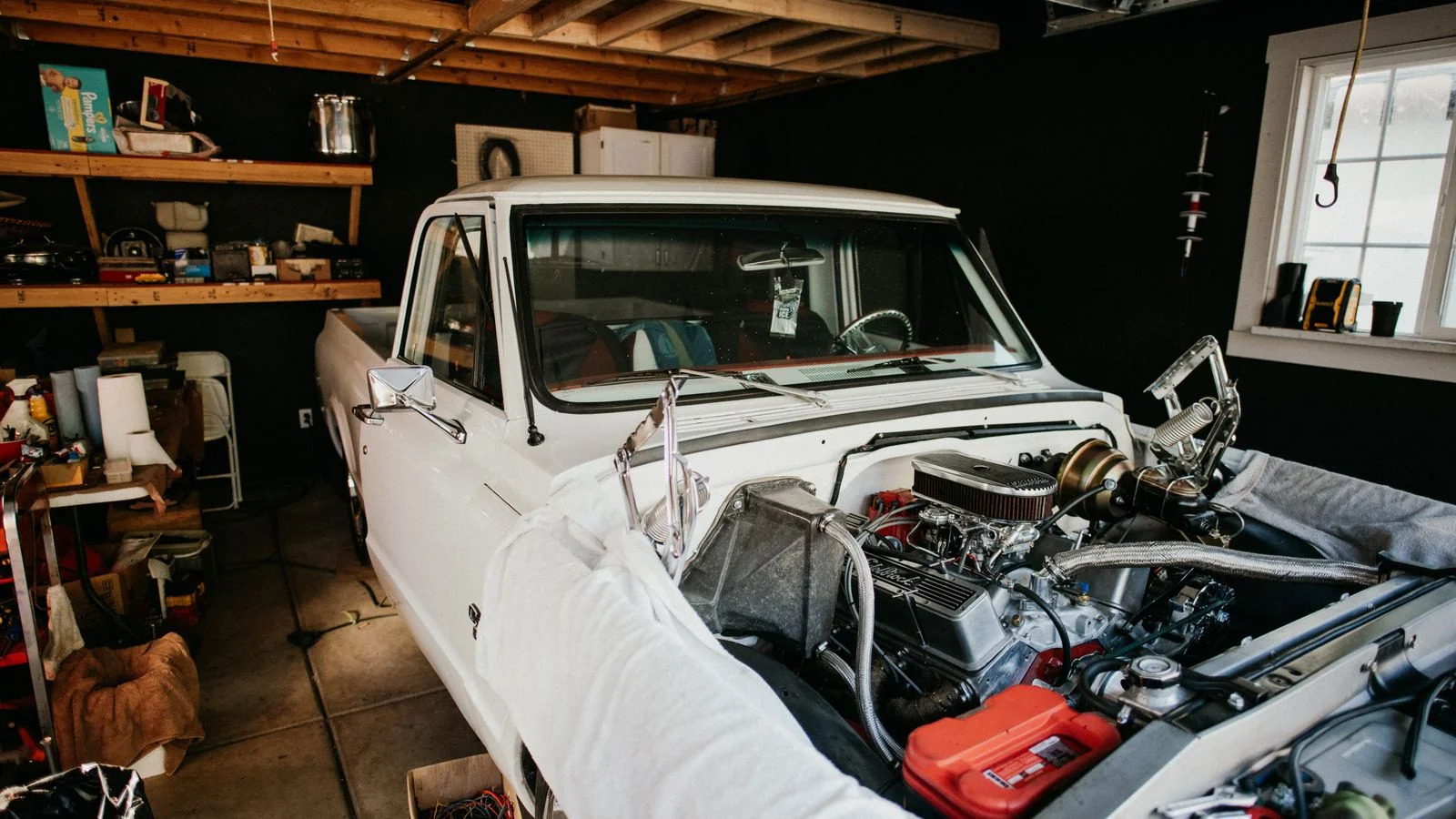 A mechanic working on a truck engine in a well-equipped garage.