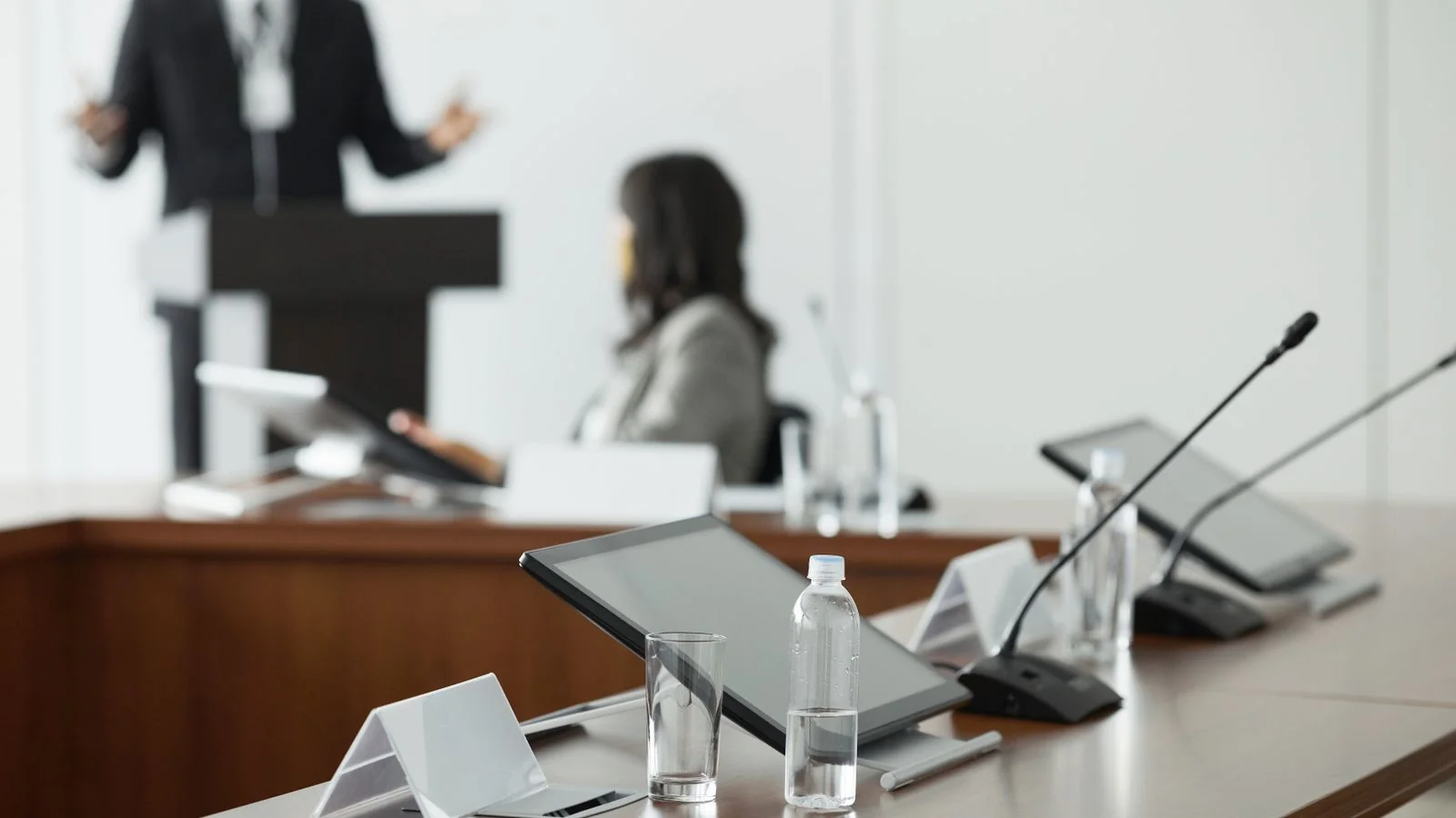 A conference room set with microphones and tablets, where positions get tested in public