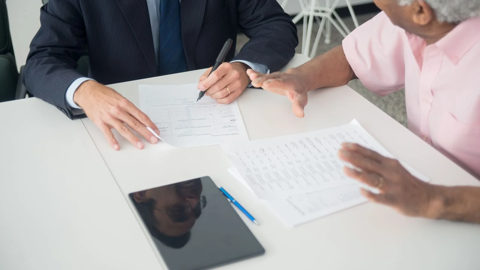 A consultant and a client reviewing documents at a table, the conversation a venue operator has hundreds of times a year.