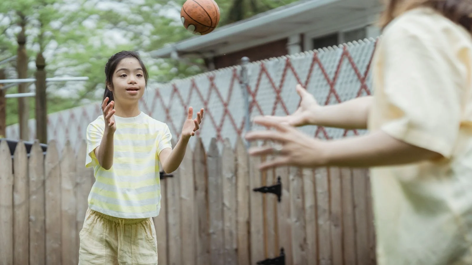 A child plays happily in a secure, fenced backyard on a sunny afternoon.