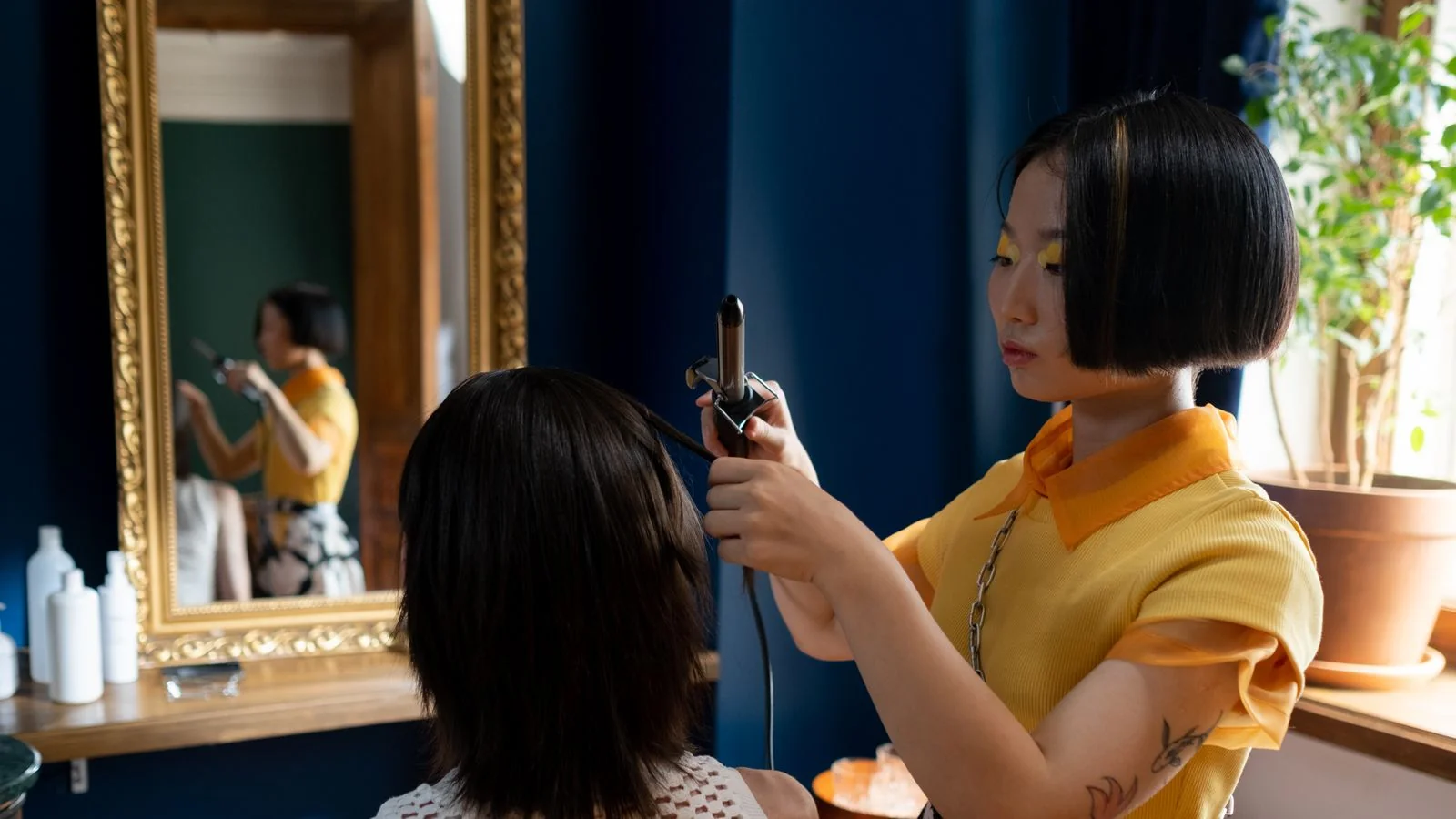 A stylist working through a client's hair in a bright salon, the daily judgment calls that make a professional worth consulting