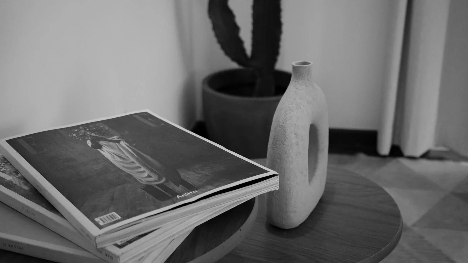 Black-and-white still life of stacked design magazines, where a stated position eventually lands.