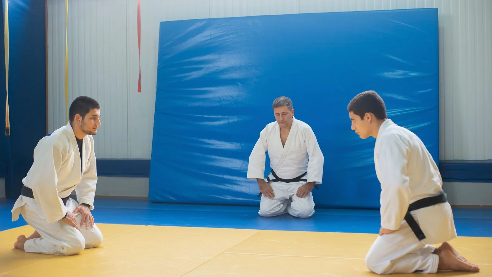 Students training under instruction in a judo dojo