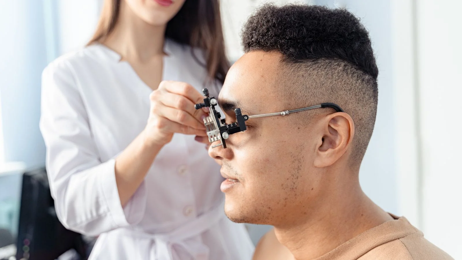 An optometrist advises a patient choosing eyewear during a consultation in the exam room.