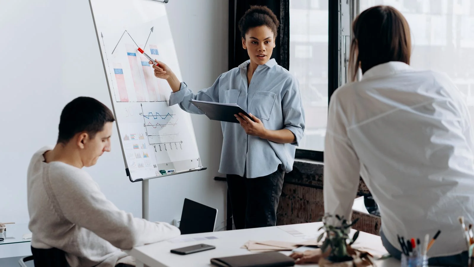 A professional explaining figures to colleagues around a meeting table.