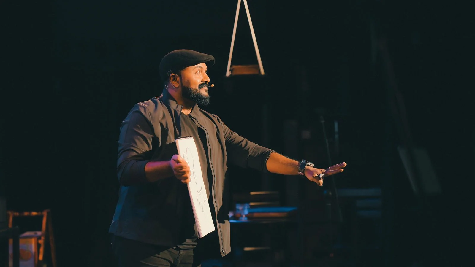 A speaker presenting from a small stage with a microphone, the invitation that follows from having a position