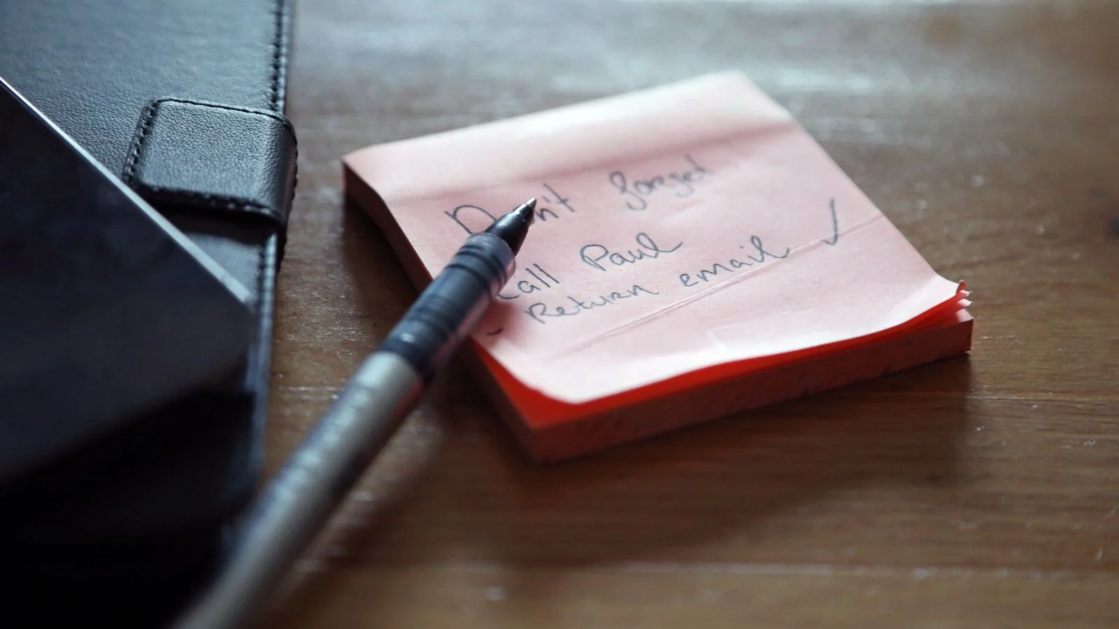 Sticky notes with a handwritten list, a pen and a wallet on a wooden desk, the unglamorous start of a real argument