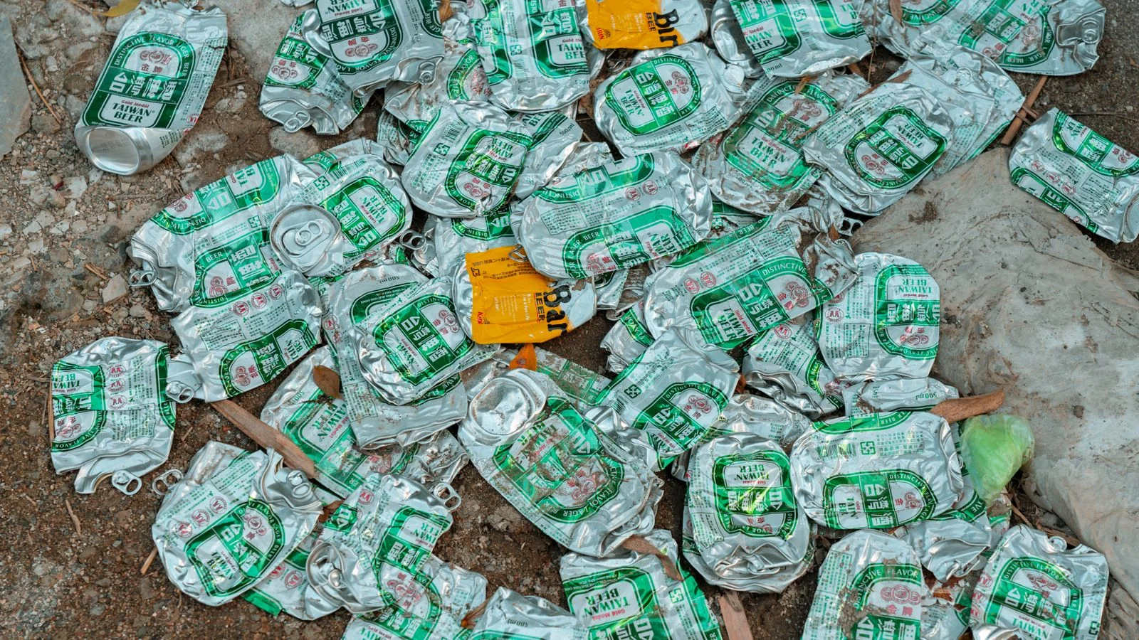 Crushed aluminum cans scattered on the ground, the most valuable material in the stream and the least understood.