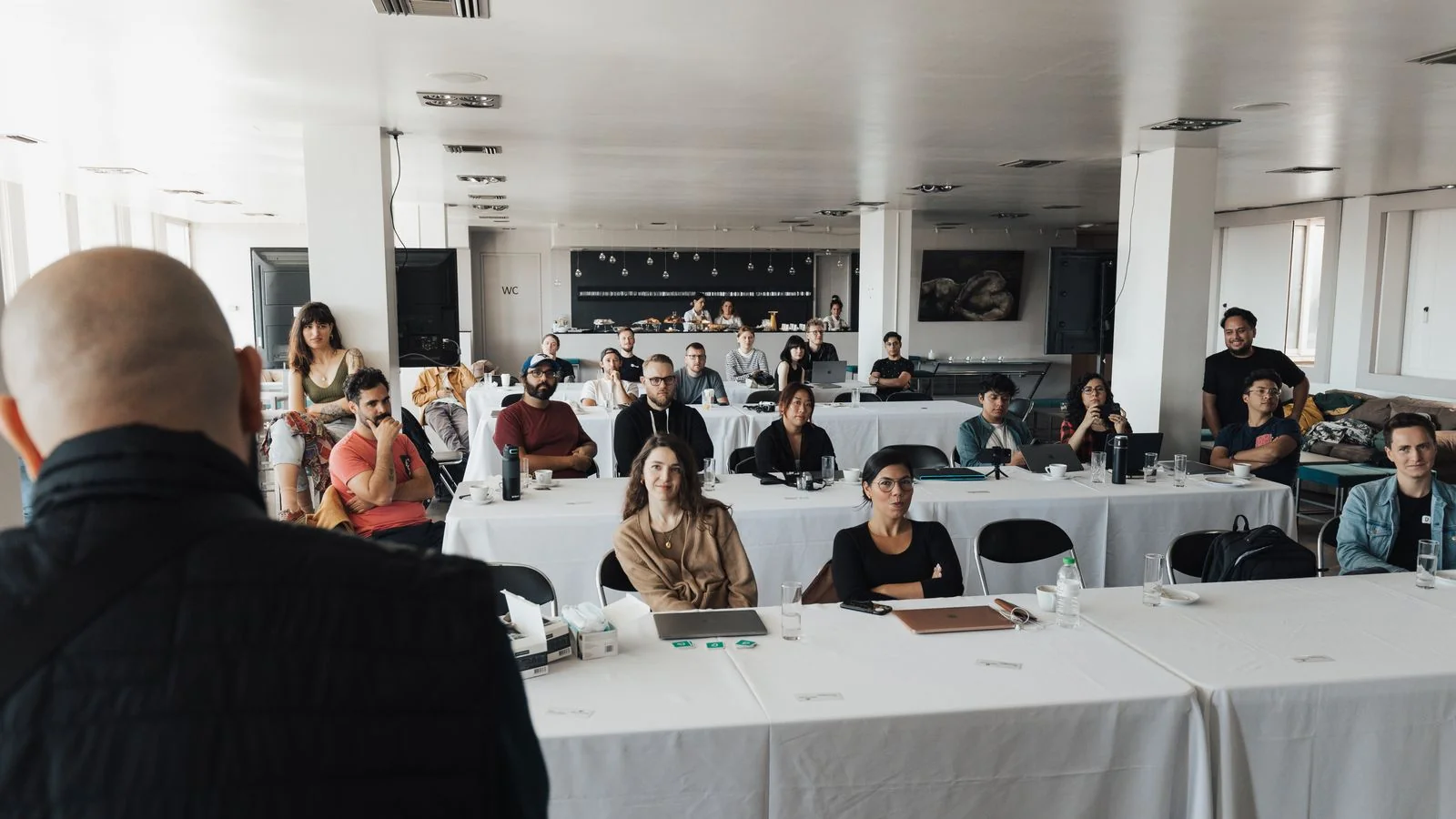 A group of professionals in a conference room presentation, the rooms wellness practitioners should be speaking in