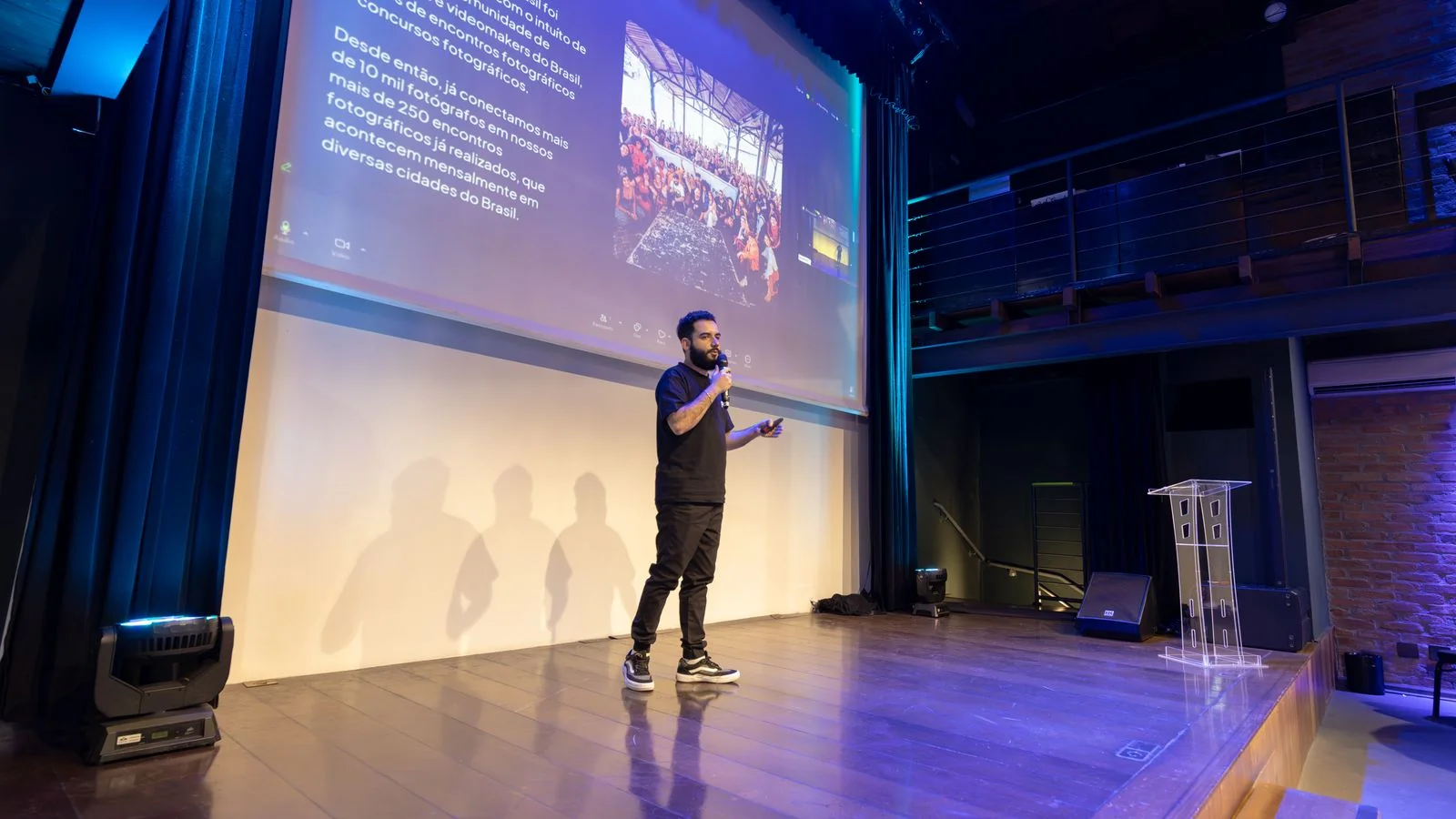 A conference speaker beside a projected slide, personality and presence doing the work of a personal brand