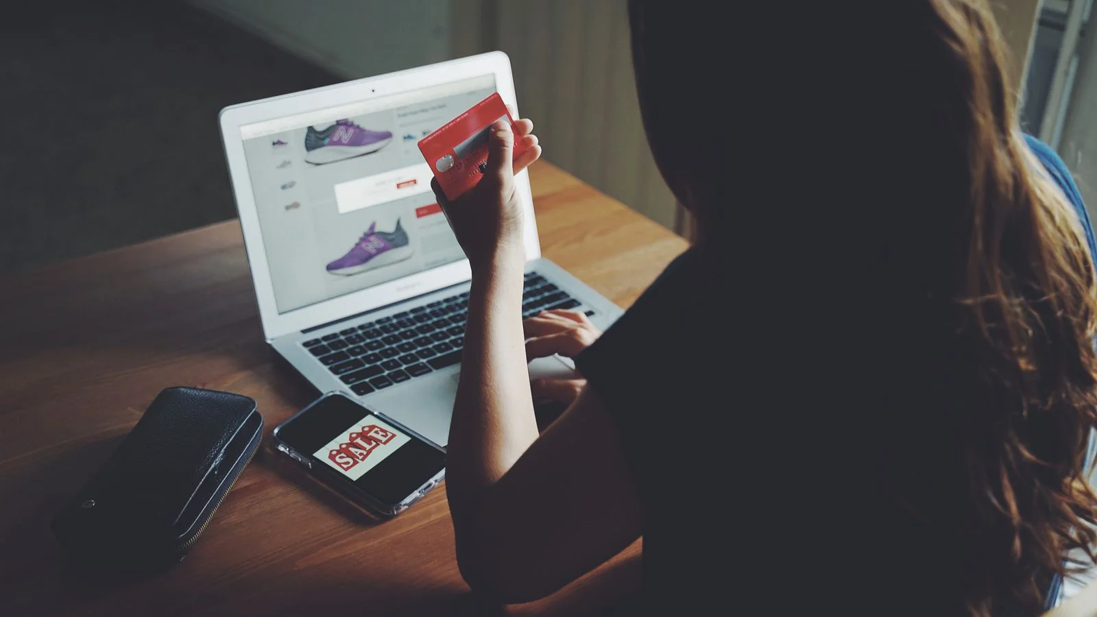 A shopper using a laptop and card at a kitchen table, the transaction a review is attached to