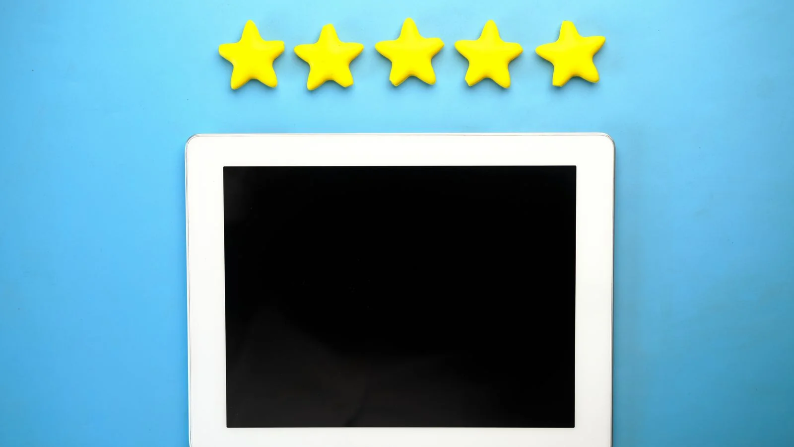 A tablet showing five stars on a blue screen, the compressed reassurance a searching buyer wants