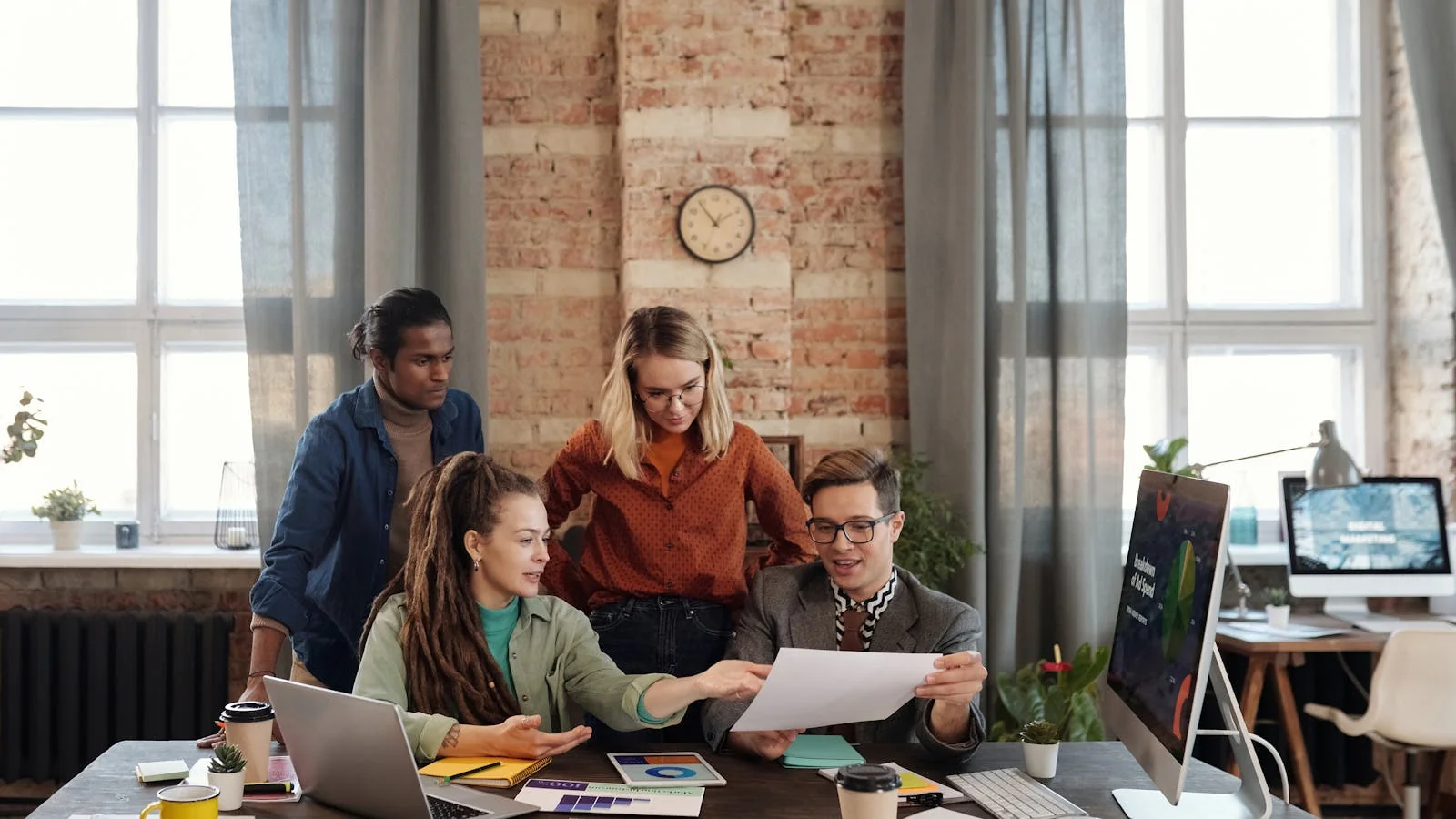 A team discussing strategy and content plans at an office desk.