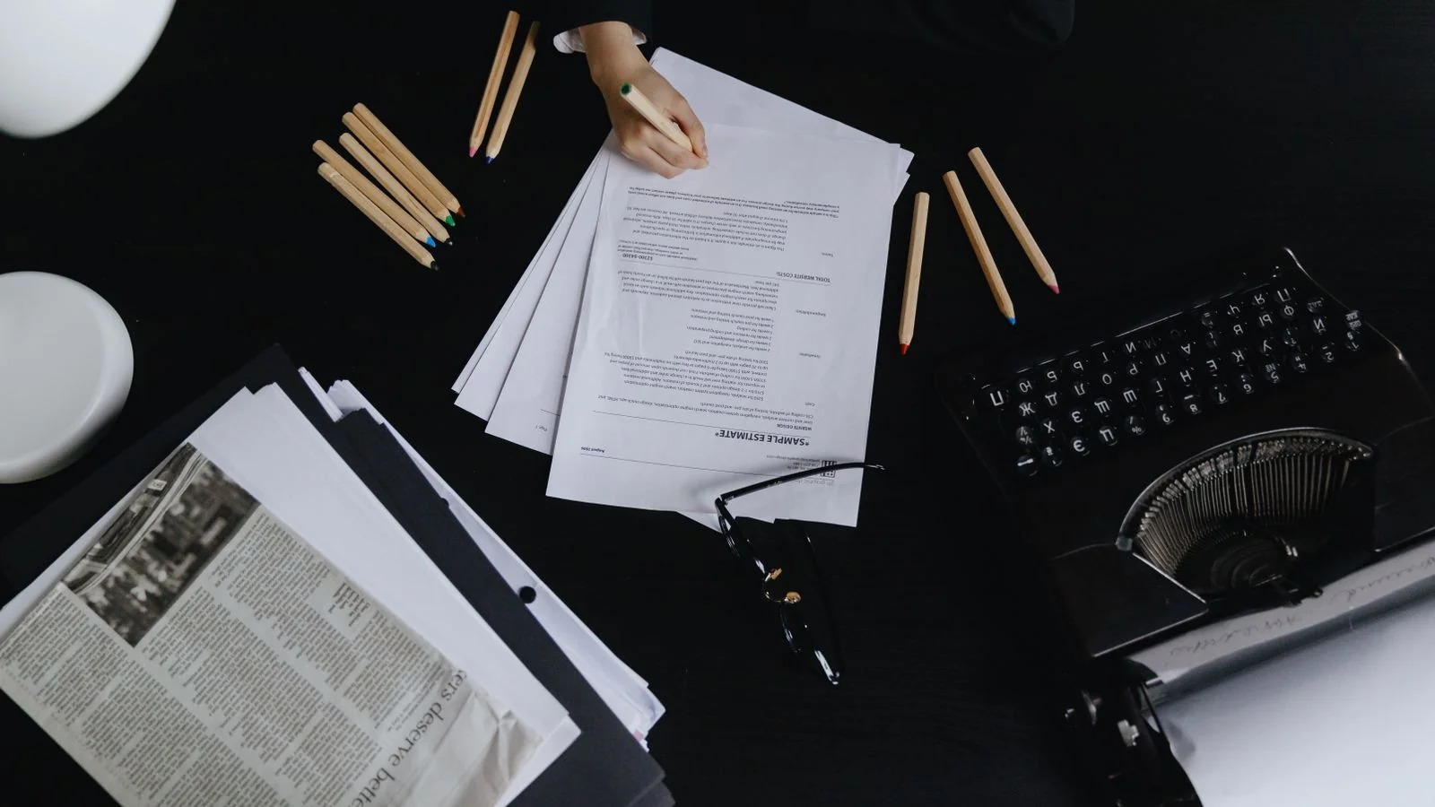 A desk with papers and a typewriter from above, where launch copy either earns a read or does not