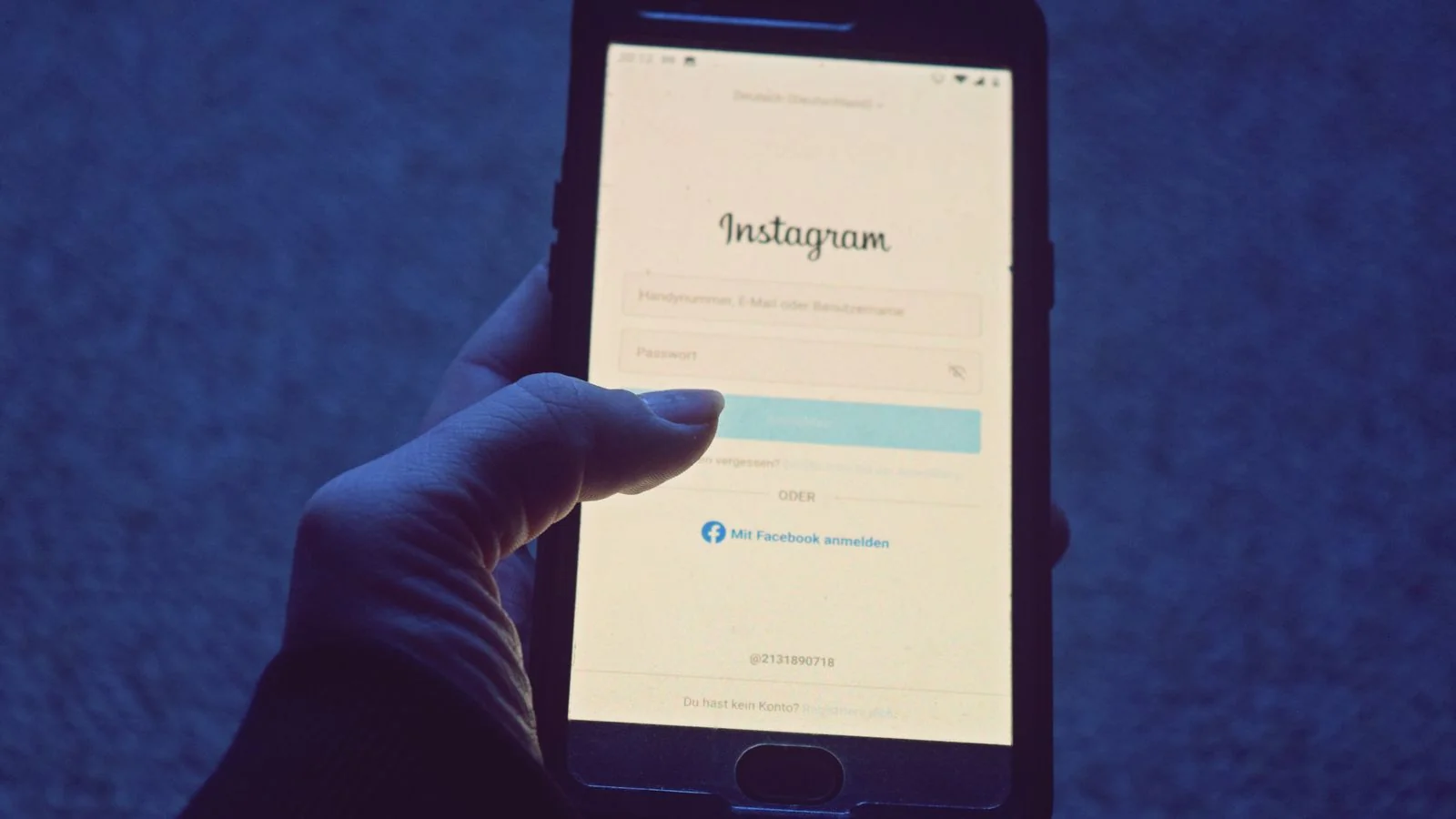 Hand holding a phone open to the Instagram login screen, one of the profiles that ranks for a name